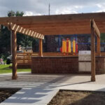 Outdoor Kitchen with a Slatted Pergola Built by MADS Lawn and Landscape Specialists